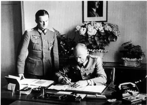 Walter Dornberger signing papers in his office in Berlin or Peenemünde sometime - фото 23