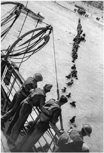 British soldiers form a human chain to wade through the surf during the - фото 56