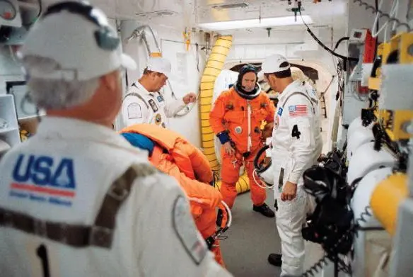 Donning my harness prior to entering space shuttle Endeavour as the commander - фото 44