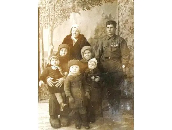 Маленькая мама на коленях слева Рядом братья Коля и Алеша во время войны - фото 3