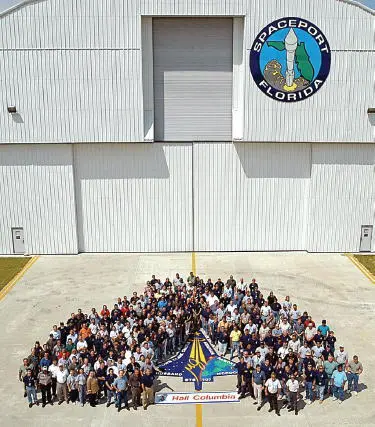 Reconstruction staff members gather around an STS107 emblem on the runway - фото 70