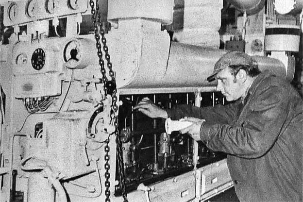 2й механик В В Турнас обслуживает один из главных двигателей судна 1976 г - фото 4
