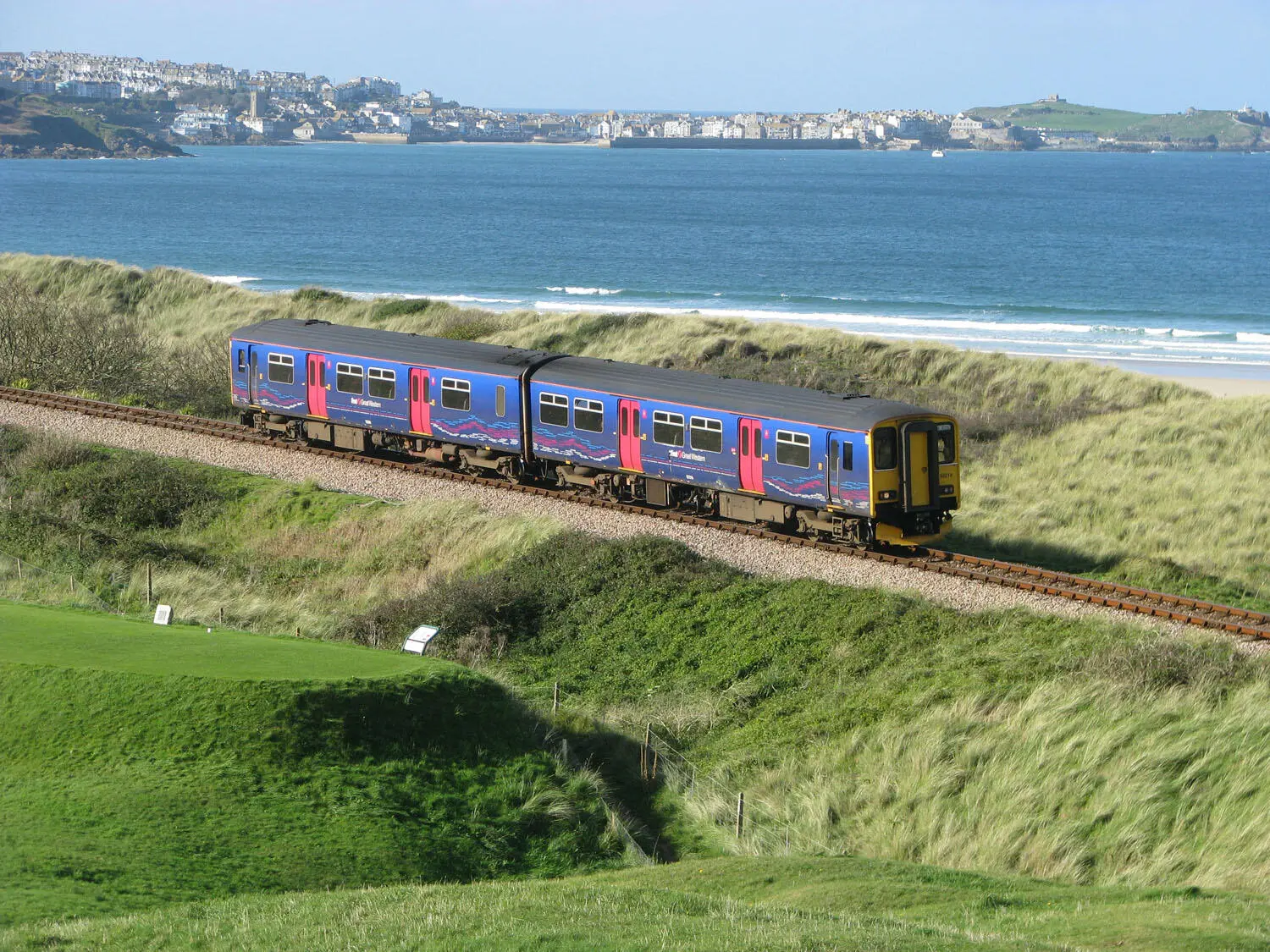 Sandwiched between a golf course and sand dunes a train for St Ives heads away - фото 12