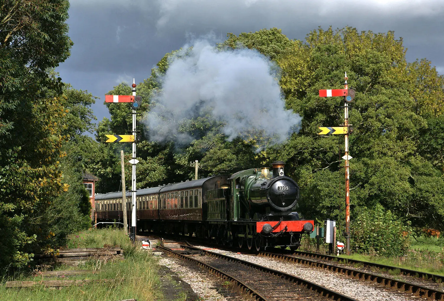 Hauled by a restored GWR locomotive a passenger train makes its way along the - фото 26
