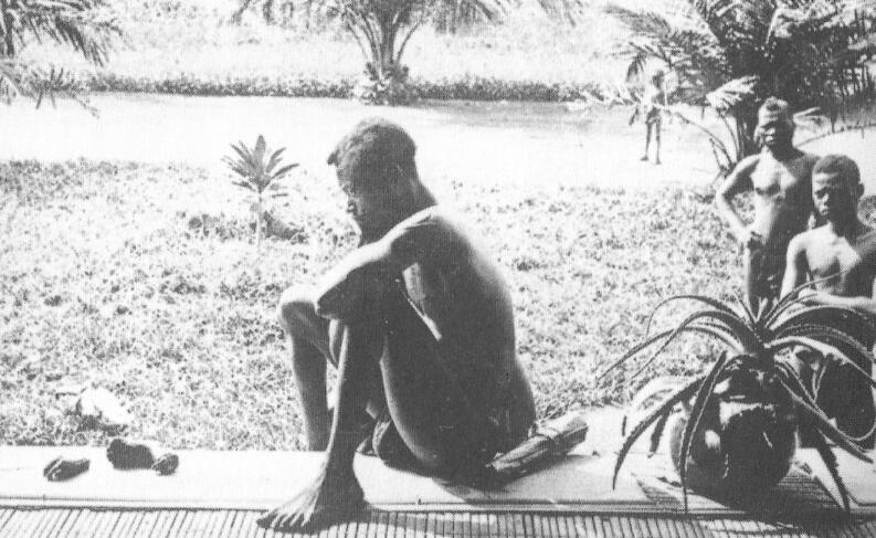 Житель округа Вала бельгийской колонии Конго смотрит на отрубленную руку и ногу - фото 1