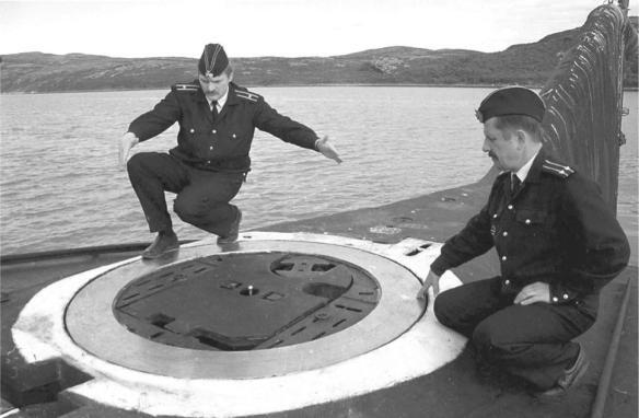 Two Russian specialists examining the emergency hatch on one of the Kursk s - фото 14