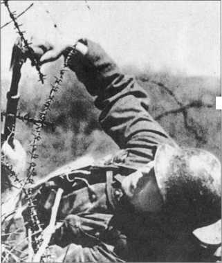 Солдат преодолевает заграждение из колючей проволоки используя средства - фото 10