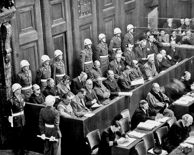 Нюрнбергский процесс 1945 г На скамье подсудимых в первом ряду Геринг Гесс - фото 23